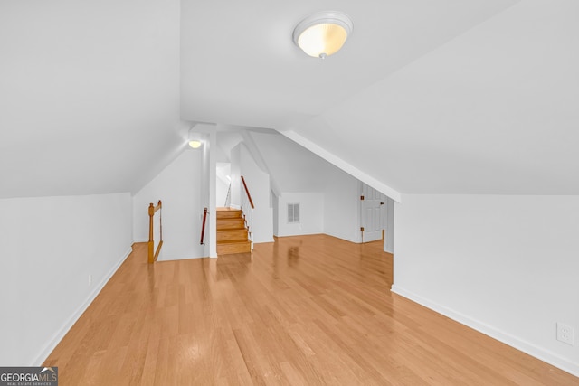 bonus room with hardwood / wood-style floors and vaulted ceiling