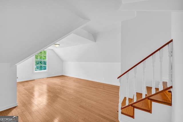 bonus room with light hardwood / wood-style floors and lofted ceiling