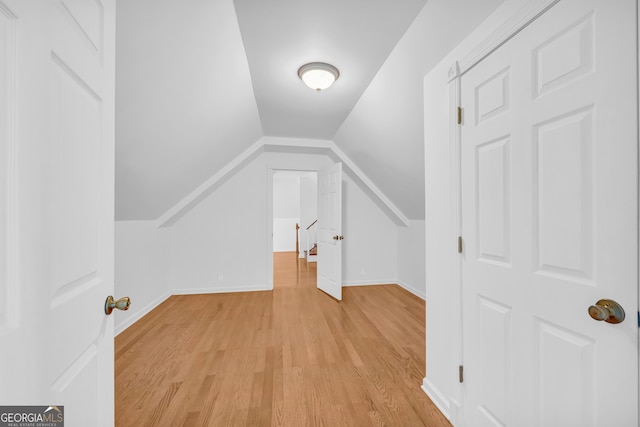 additional living space with light hardwood / wood-style floors and vaulted ceiling