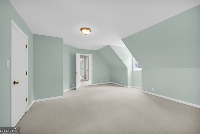 additional living space with lofted ceiling and light carpet