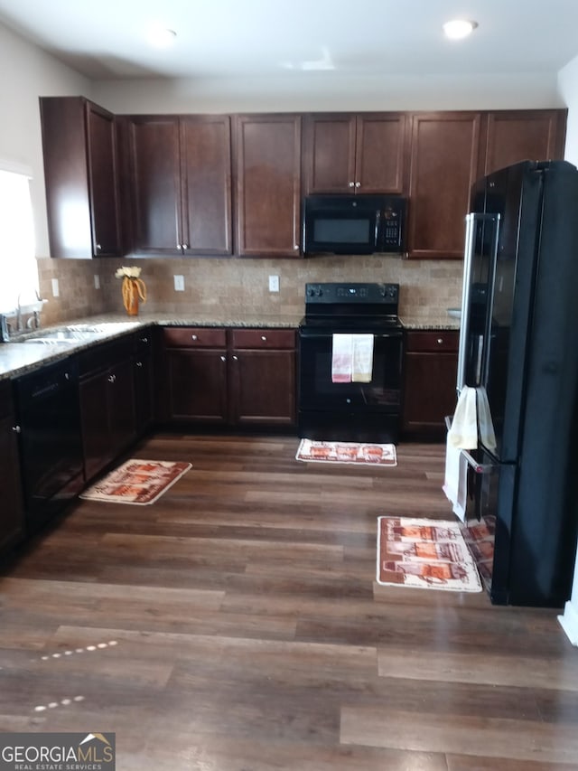 kitchen featuring black appliances, dark hardwood / wood-style floors, dark brown cabinetry, and sink