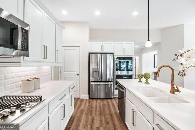 kitchen featuring white cabinets, decorative backsplash, sink, and stainless steel appliances