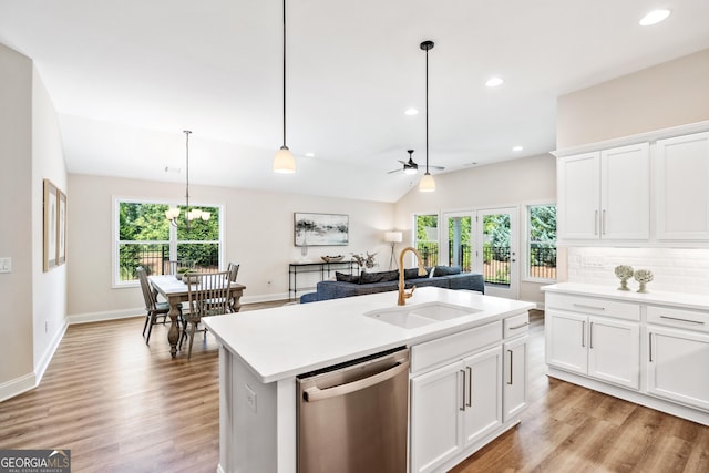 kitchen featuring white cabinetry, stainless steel dishwasher, a center island with sink, and sink