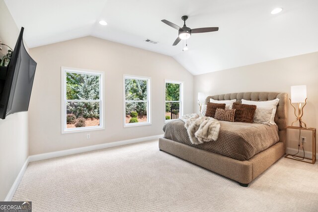 bedroom featuring light carpet, vaulted ceiling, and ceiling fan