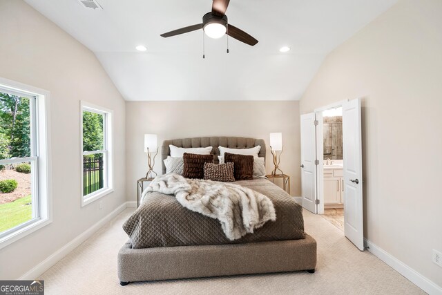 carpeted bedroom with ceiling fan, lofted ceiling, and connected bathroom