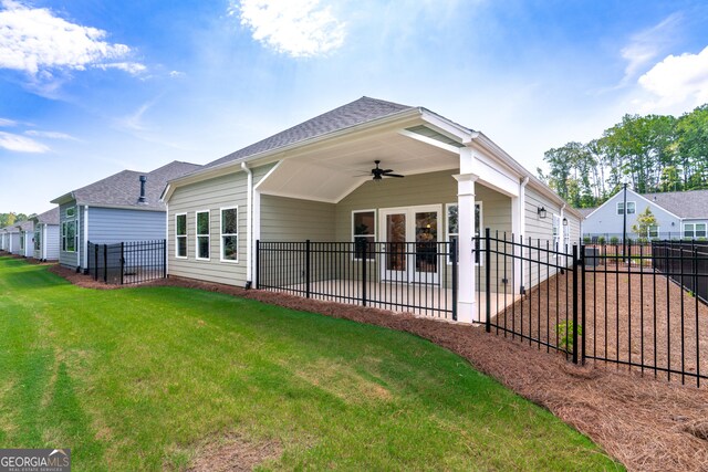 rear view of house featuring french doors, ceiling fan, and a lawn