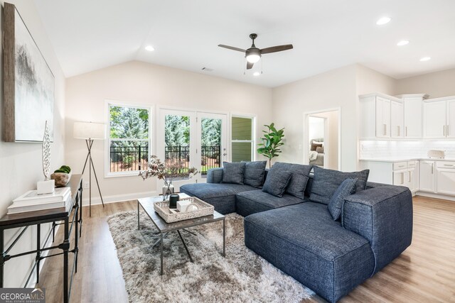 living room with ceiling fan, light wood-type flooring, french doors, and lofted ceiling