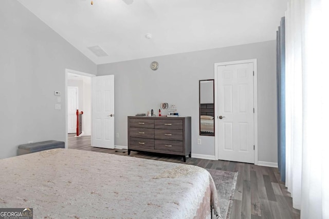 bedroom featuring dark wood-type flooring and vaulted ceiling