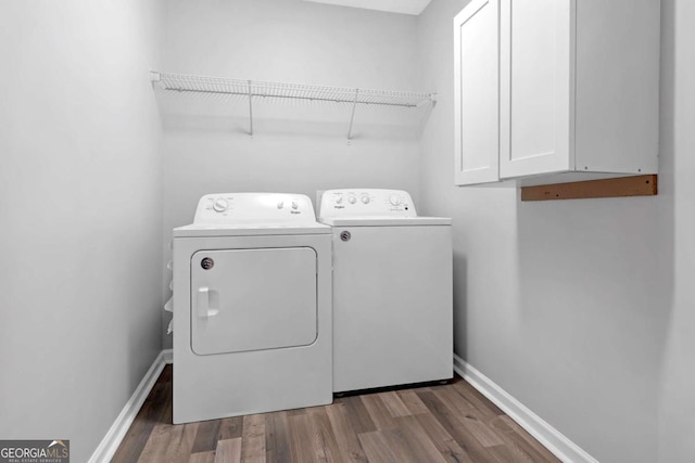 washroom with cabinets, dark hardwood / wood-style floors, and washer and clothes dryer