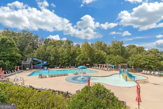 view of swimming pool with pool water feature, a patio area, and a water slide