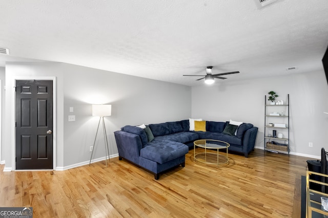 living room featuring hardwood / wood-style floors, a textured ceiling, and ceiling fan