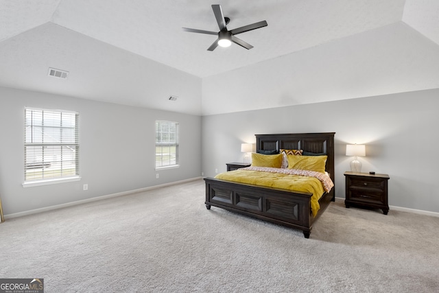 carpeted bedroom featuring multiple windows, a raised ceiling, ceiling fan, and lofted ceiling