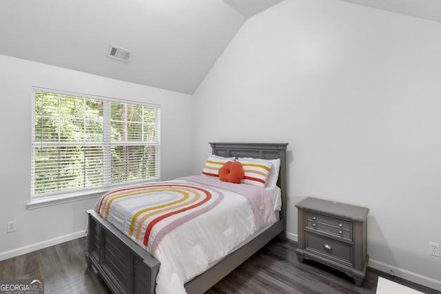 bedroom with vaulted ceiling, dark wood-type flooring, and multiple windows