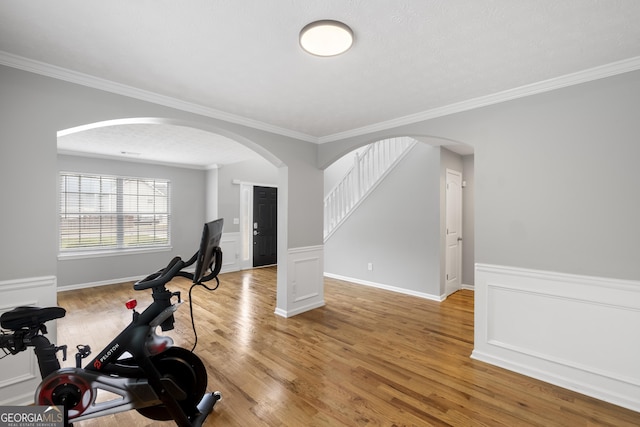 workout area with hardwood / wood-style flooring and crown molding