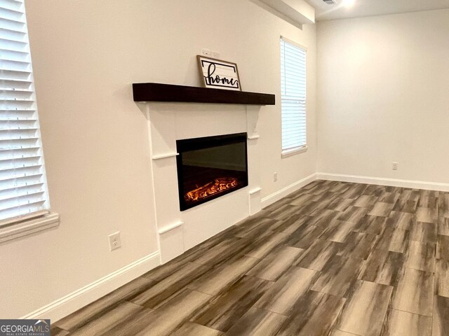 unfurnished living room with dark hardwood / wood-style flooring