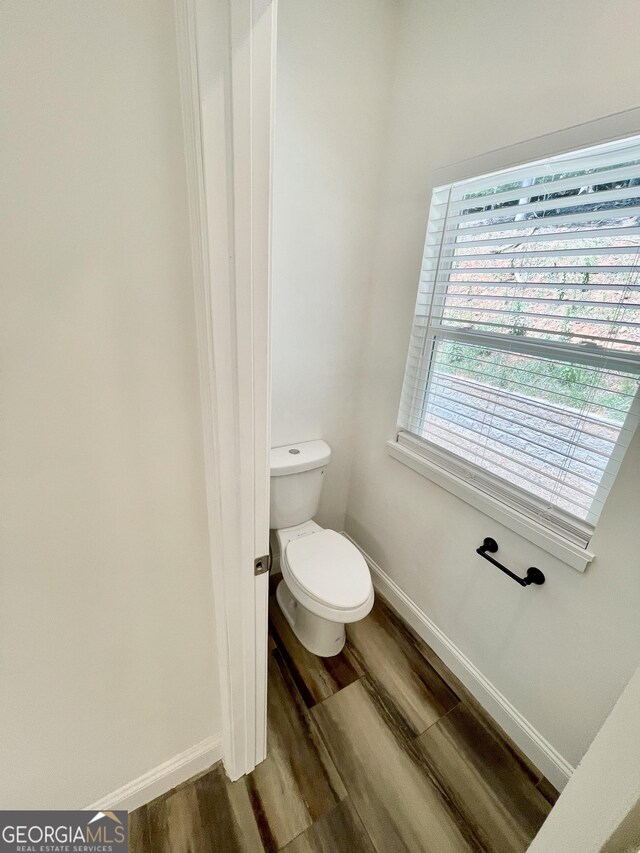 bathroom featuring toilet and wood-type flooring