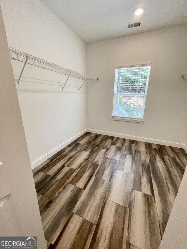 spacious closet with dark hardwood / wood-style floors