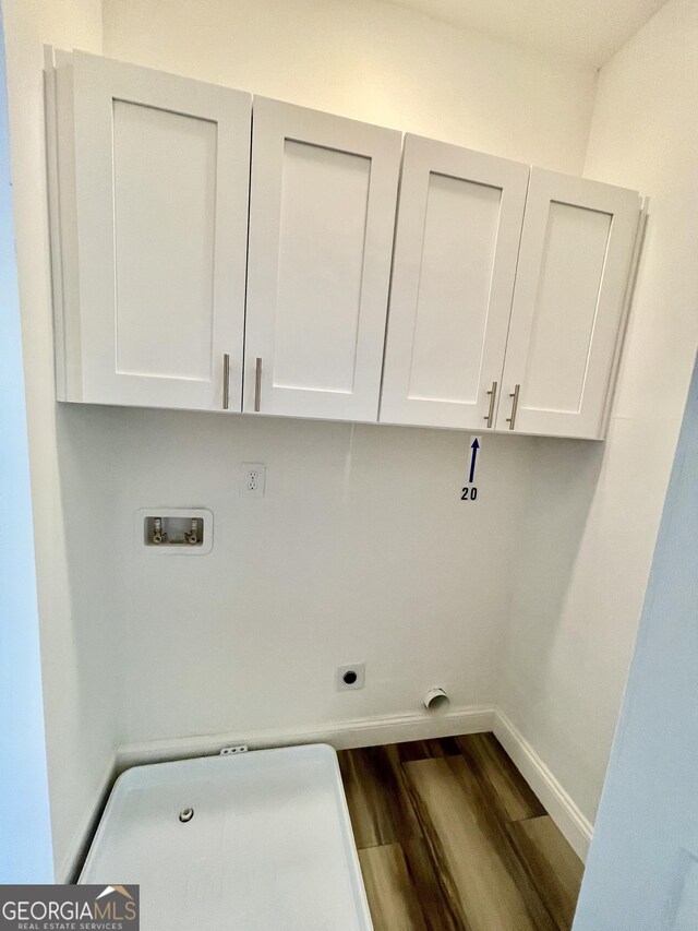 laundry room featuring hookup for an electric dryer, washer hookup, dark wood-type flooring, and cabinets