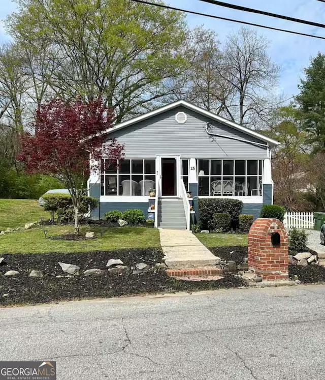 view of front of home featuring a front lawn and a sunroom