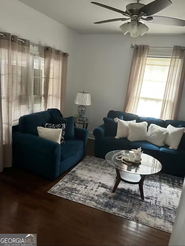 living room featuring ceiling fan and dark hardwood / wood-style floors