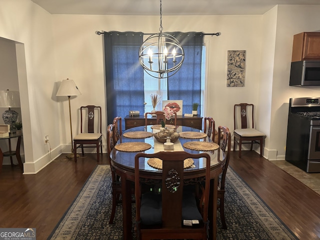 dining space with an inviting chandelier and dark hardwood / wood-style flooring