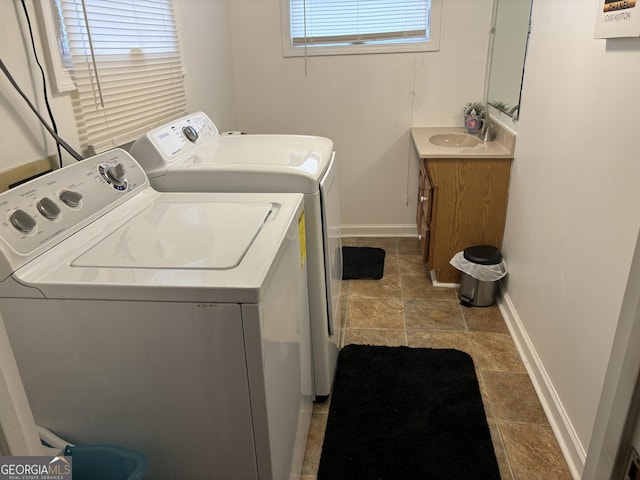 clothes washing area with sink and washing machine and clothes dryer