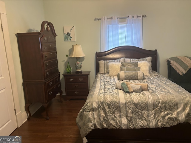 bedroom with dark hardwood / wood-style floors