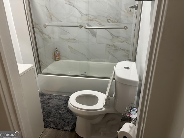 bathroom featuring enclosed tub / shower combo, toilet, and hardwood / wood-style floors