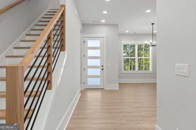 foyer with a notable chandelier and light wood-type flooring