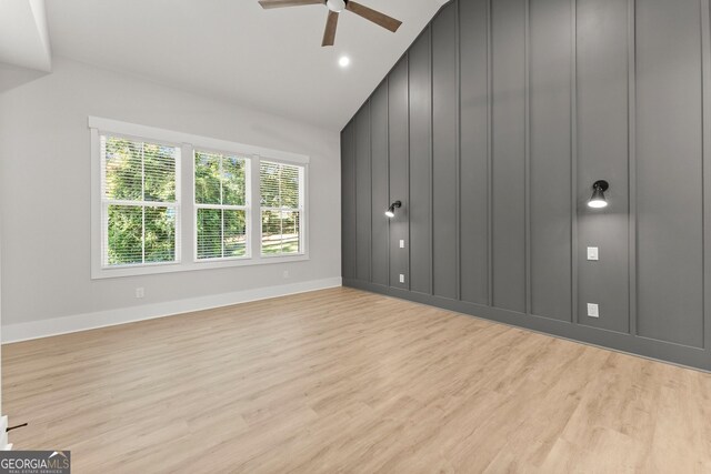 interior space with ceiling fan, vaulted ceiling, and light wood-type flooring