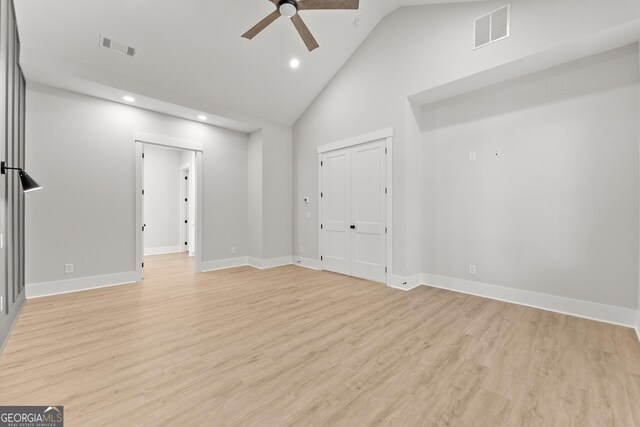 empty room with ceiling fan, high vaulted ceiling, and light hardwood / wood-style floors