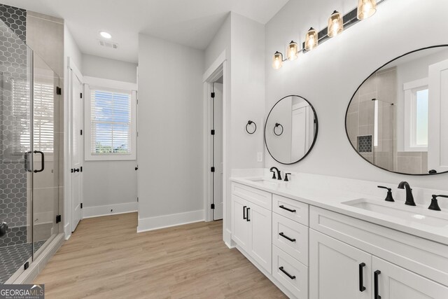 bathroom featuring vanity, hardwood / wood-style flooring, and a shower with door