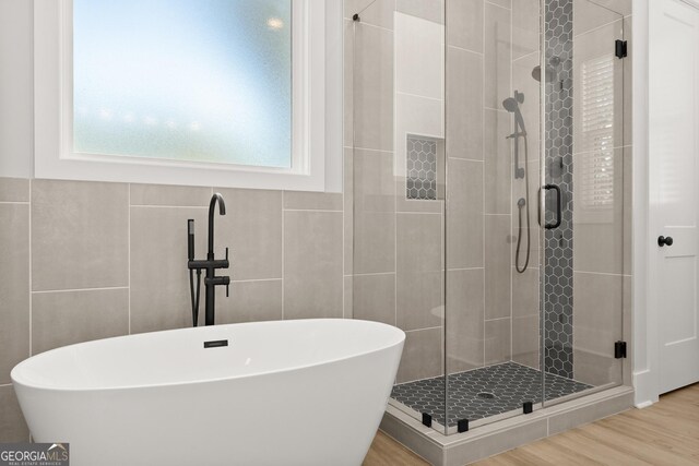 bathroom featuring hardwood / wood-style flooring and independent shower and bath