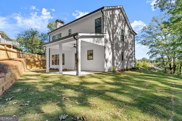 rear view of house featuring a patio, ceiling fan, and a lawn