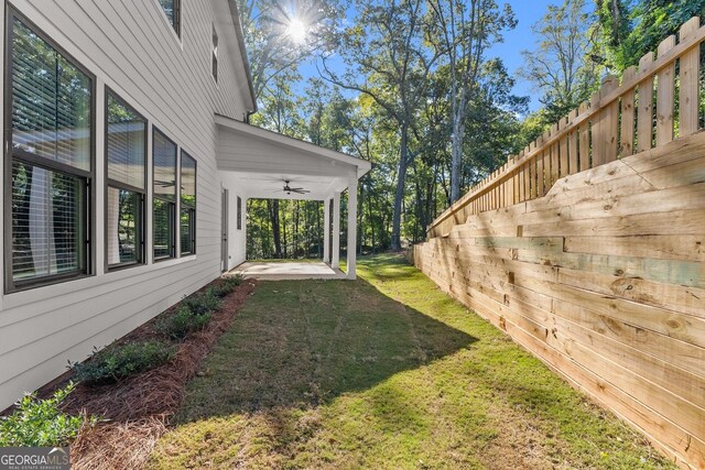 view of yard featuring ceiling fan and a patio