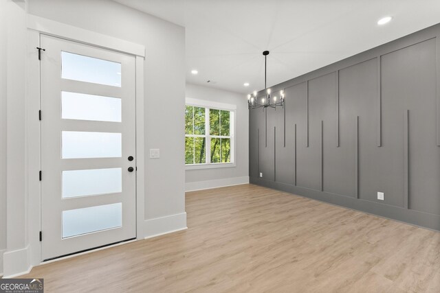 entryway featuring light hardwood / wood-style floors and an inviting chandelier