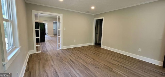 empty room with dark hardwood / wood-style flooring and ornamental molding