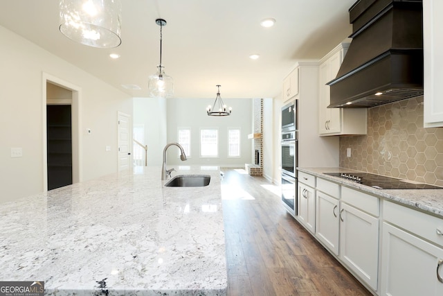 kitchen featuring black electric cooktop, sink, white cabinetry, and custom exhaust hood