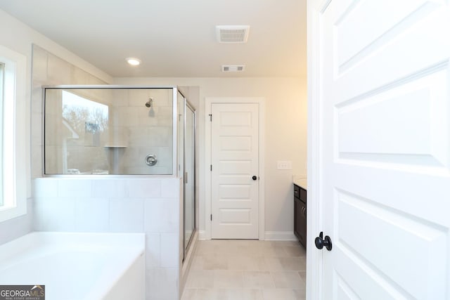 bathroom featuring vanity, tile patterned flooring, plenty of natural light, and plus walk in shower