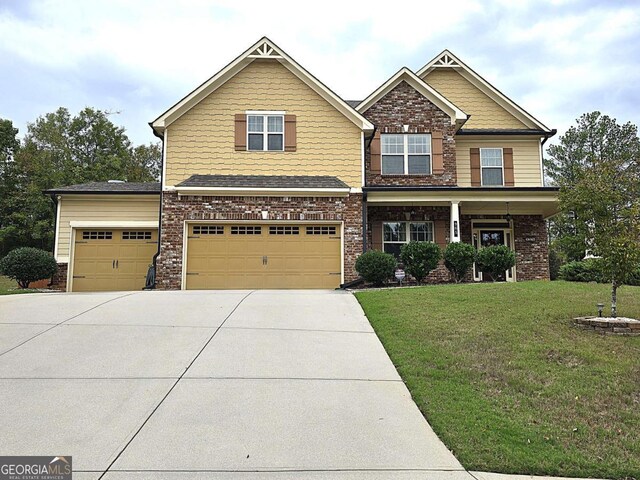 craftsman inspired home featuring a front yard and a garage