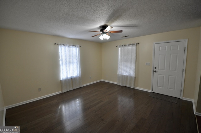 unfurnished room featuring a textured ceiling, ceiling fan, and dark hardwood / wood-style floors