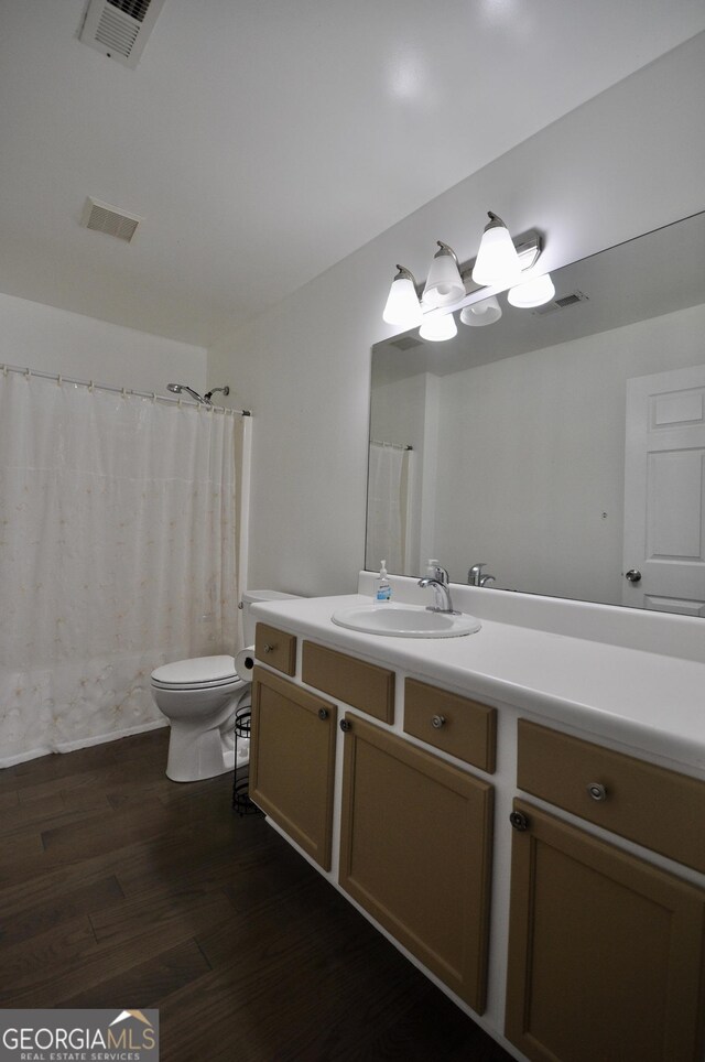 bathroom featuring toilet, vanity, and hardwood / wood-style flooring