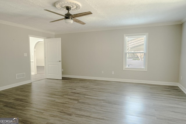 spare room featuring a textured ceiling, dark hardwood / wood-style flooring, ceiling fan, and crown molding