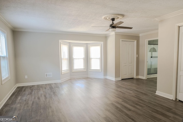 spare room featuring ceiling fan, plenty of natural light, dark hardwood / wood-style floors, and ornamental molding