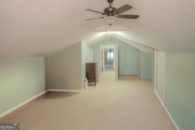 additional living space with ceiling fan, light colored carpet, and lofted ceiling