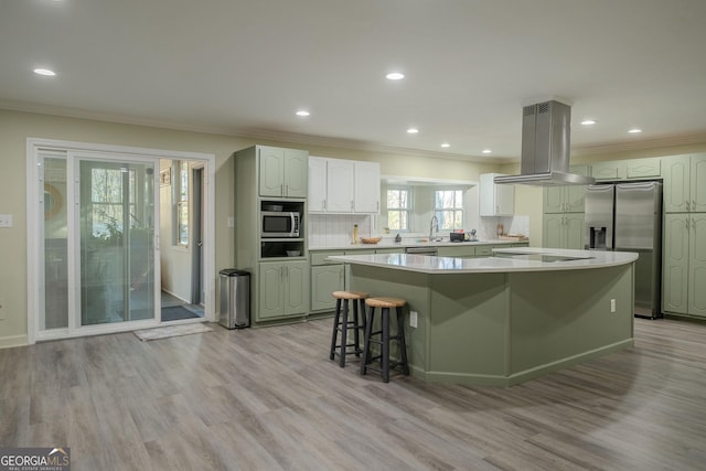 kitchen featuring backsplash, a breakfast bar area, a kitchen island, island range hood, and stainless steel appliances