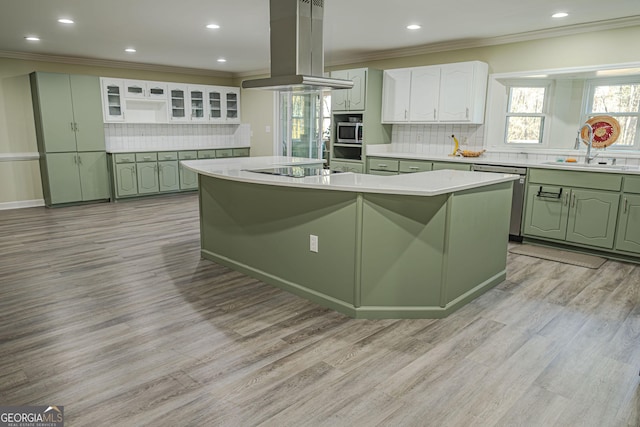 kitchen featuring white cabinetry, island range hood, sink, and an island with sink