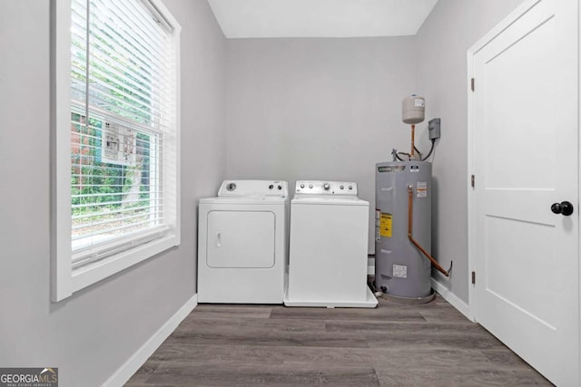 clothes washing area with washer and dryer, wood-type flooring, and electric water heater