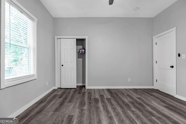 unfurnished bedroom featuring dark hardwood / wood-style flooring, multiple windows, and ceiling fan