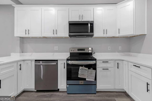 kitchen featuring light stone countertops, white cabinetry, dark wood-type flooring, and appliances with stainless steel finishes